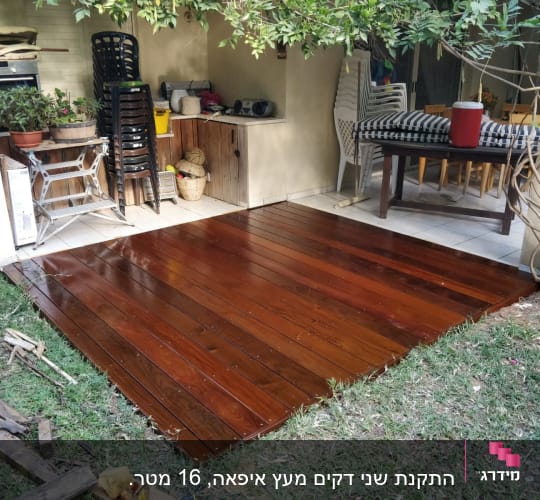 דק עץ חדש בגינה עם צמחייה מסביב